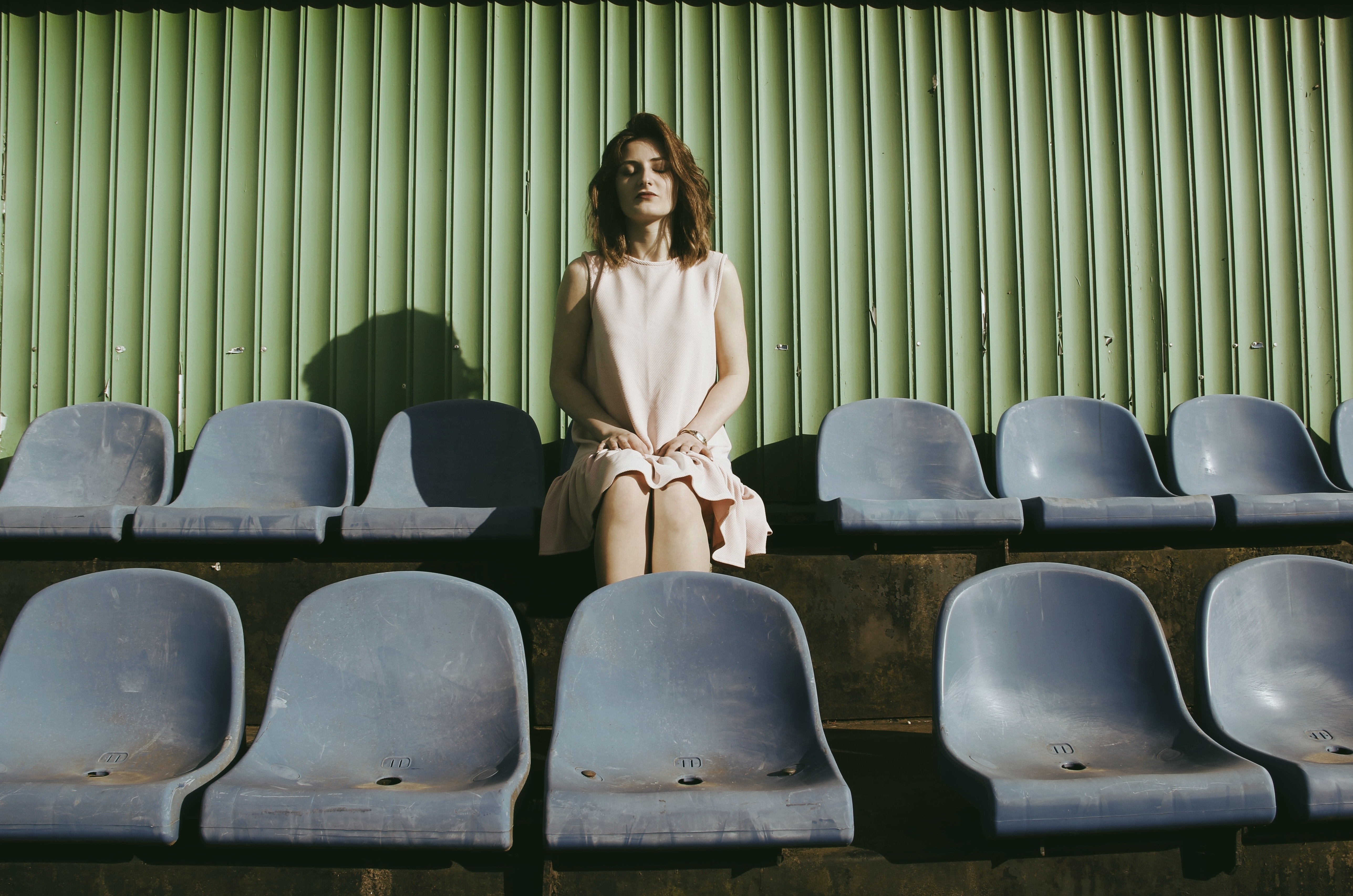 Woman sitting mindfully in empty stadium seats